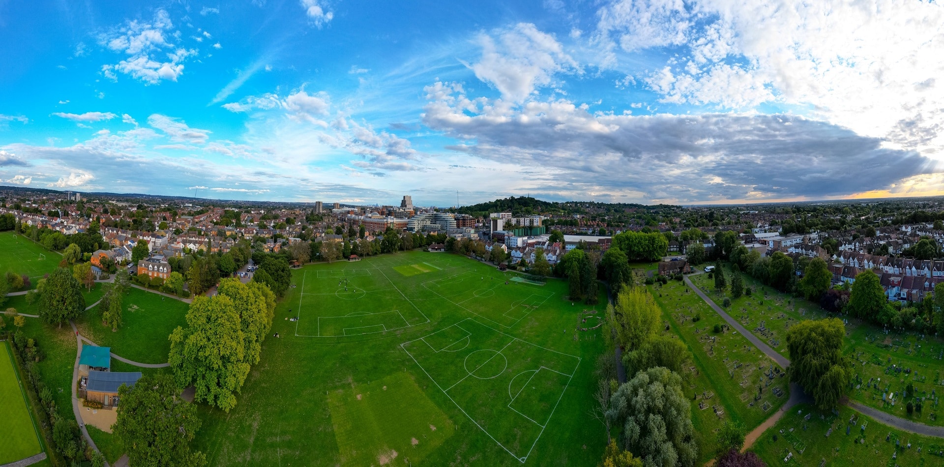 Panoramic view of the green football field and blue cloudy sky Harrow, Greater London, England