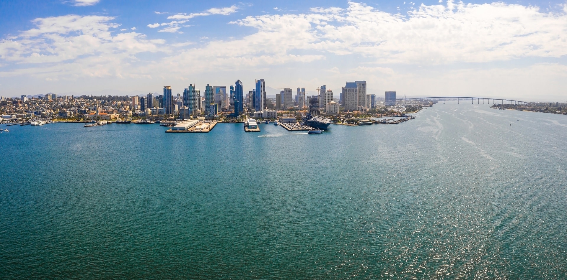 An aerial panoramic shot of the London city skyline near the water on a bright day